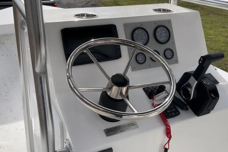 Slide: The Image of 2024 C-Hawk 23 Center Console boat dashboard with steering wheel and controls. - 4