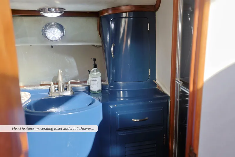 Slide: The Image of 1988 Mediterranean 38 Convertible yacht bathroom with blue sink and cabinetry. - 21