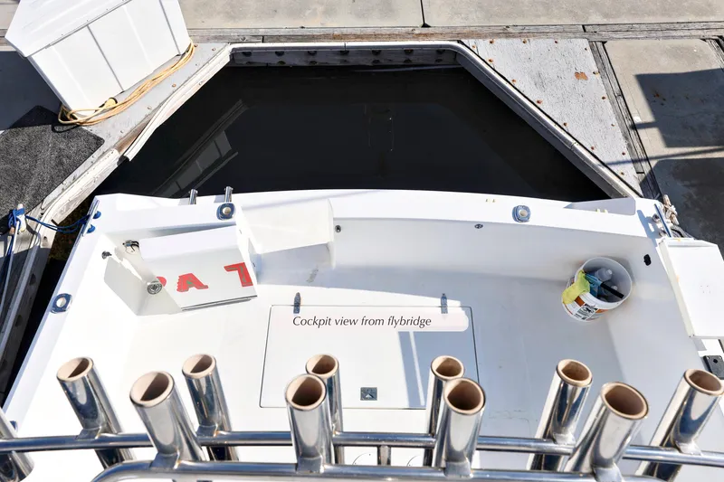 Slide: The Image of Cockpit view of 1988 Mediterranean 38 Convertible boat, showcasing fishing rod holders and storage. - 8