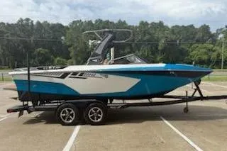 The Image of 2017 Tigé RZX2 boat on trailer, blue and white, parked outdoors. - 0