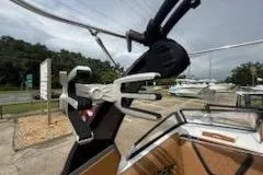 Slide: The Image of 2017 Tigé RZX2 boat with wakeboard rack, docked near other boats. - 17