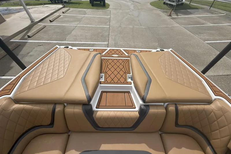Slide: The Image of 2017 Tigé RZX2 boat interior with tan quilted seats and wood accents. - 33