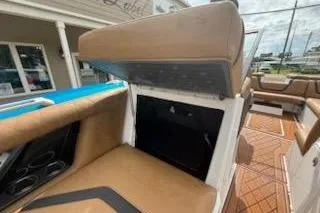 Slide: The Image of 2017 Tigé RZX2 boat interior with tan seating and storage compartment open. - 13