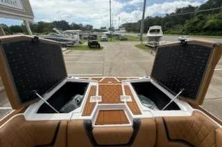 Slide: The Image of 2017 Tigé RZX2 boat with open storage compartments, parked outdoors. - 24