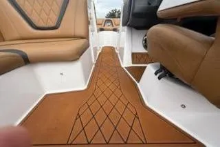 Slide: The Image of 2017 Tigé RZX2 boat interior with brown diamond-patterned flooring and seating. - 29