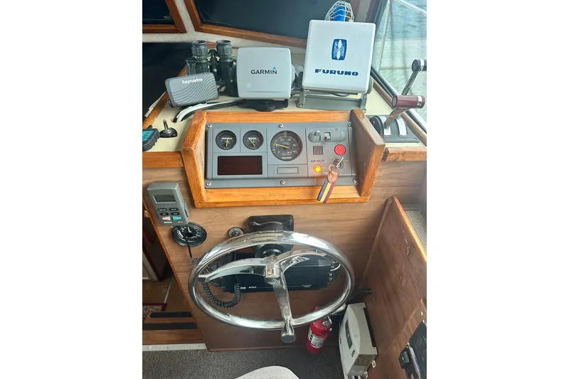 Slide: The Image of 1982 Campion 310 boat dashboard with steering wheel, gauges, and navigation equipment. - 14