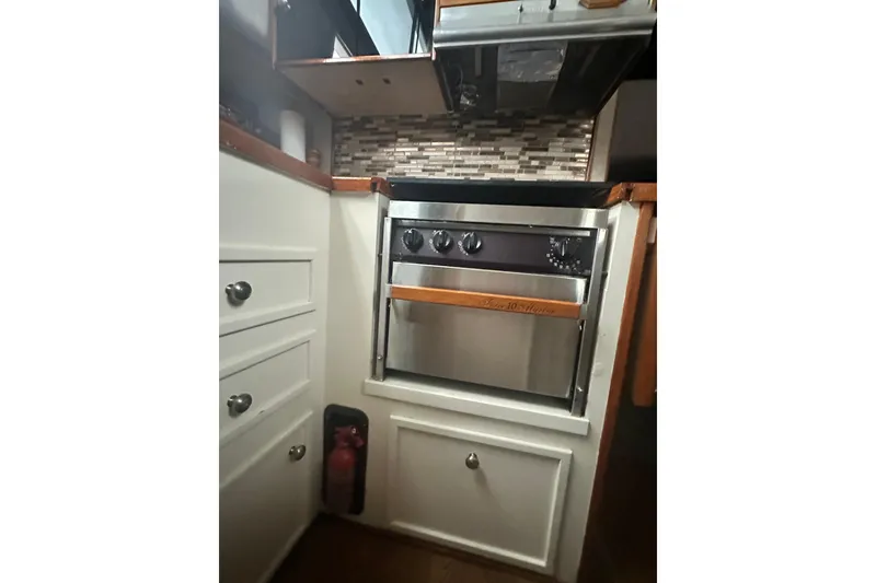 Slide: The Image of Compact kitchen area in a 1982 Campion 310 boat, featuring a stainless steel oven. - 23