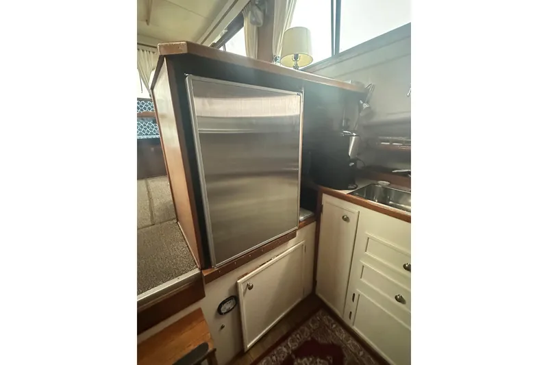 Slide: The Image of 1982 Campion 310 boat interior with compact kitchen and stainless steel fridge. - 25