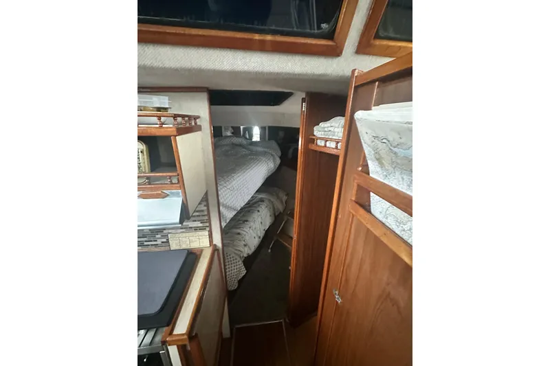 Slide: The Image of Interior of a 1982 Campion 310 boat, featuring cozy sleeping quarters and wooden cabinetry. - 28