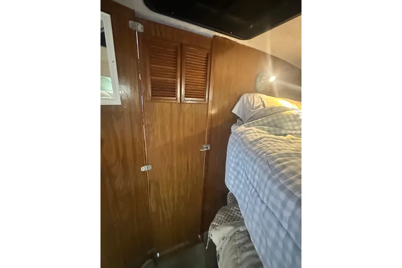 Slide: The Image of Interior of 1982 Campion 310 boat with wooden paneling and cozy bedding. - 32