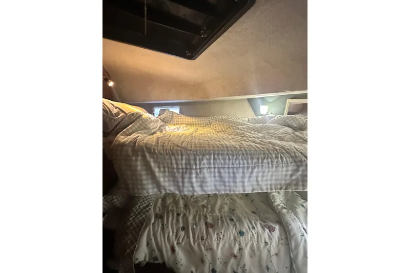 Slide: The Image of Cozy sleeping area inside a 1982 Campion 310 boat with soft lighting. - 34
