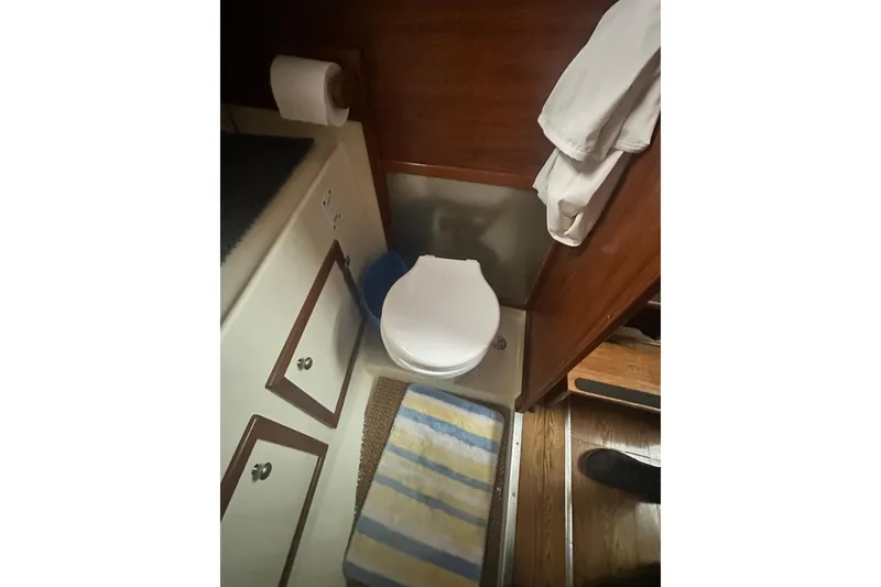 Slide: The Image of 1982 Campion 310 boat bathroom with toilet, striped mat, and wooden cabinetry. - 37
