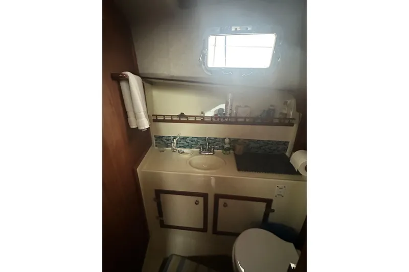 Slide: The Image of 1982 Campion 310 boat bathroom with sink, mirror, and storage cabinets. - 38