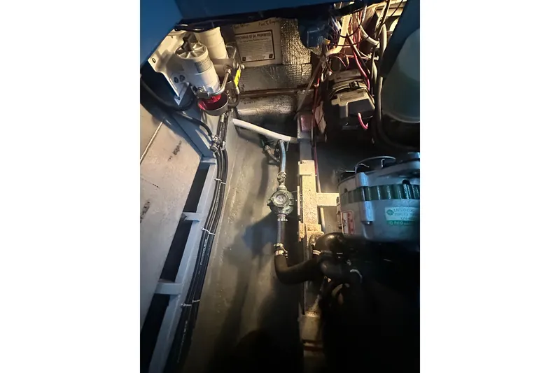 Slide: The Image of Engine compartment of a 1982 Campion 310 boat, showcasing mechanical components and wiring. - 45