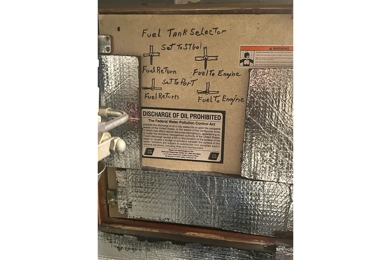 Slide: The Image of 1982 Campion 310 fuel tank selector with oil discharge warning label. - 48