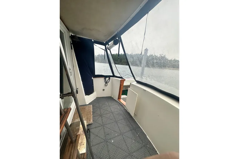 Slide: The Image of 1982 Campion 310 boat interior with covered deck, overlooking serene water and forest. - 5