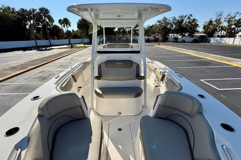 Slide: The Image of 2023 Key West 263 FS boat interior with seating, parked outdoors. - 21