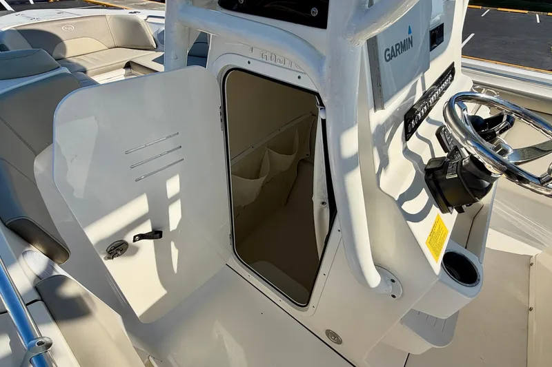 Slide: The Image of 2023 Key West 263 FS boat interior with open storage compartment and Garmin navigation system. - 23