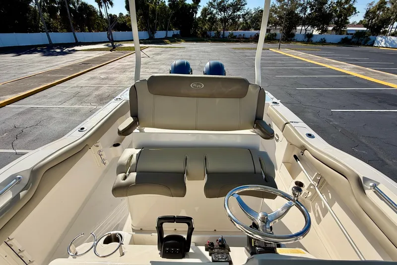 Slide: The Image of 2023 Key West 263 FS boat interior with steering wheel and seating in a parking lot. - 26
