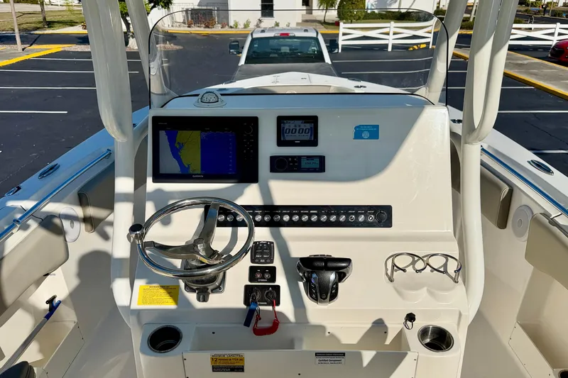 Slide: The Image of 2023 Key West 263 FS boat dashboard with steering wheel, navigation screen, and controls. - 28