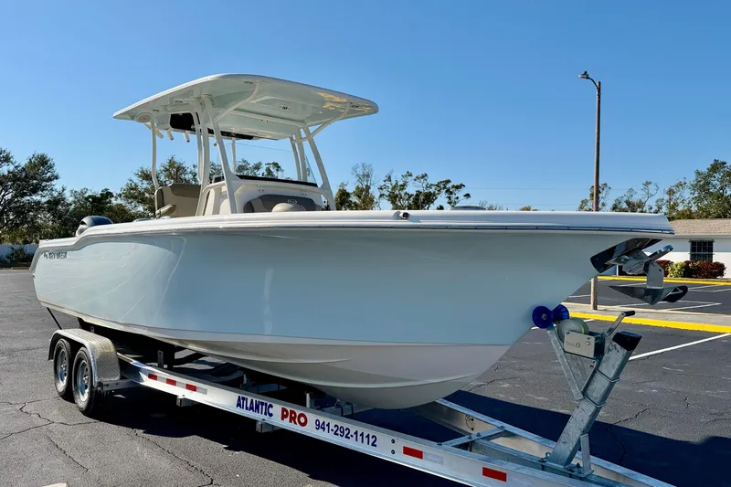Slide: The Image of 2023 Key West 263 FS boat on trailer in sunny parking lot. - 4