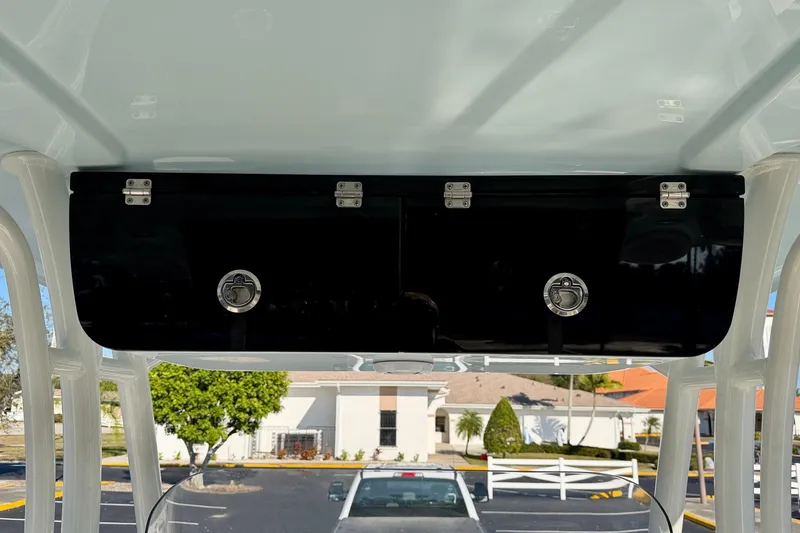 Slide: The Image of 2023 Key West 263 FS boat storage compartment with secure latches, outdoor setting. - 40