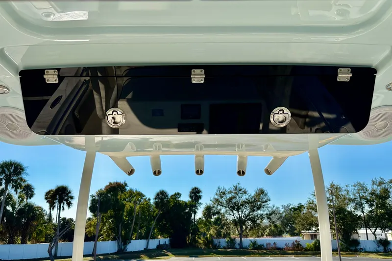 Slide: The Image of 2023 Key West 263 FS boat with rod holders and storage compartment, sunny outdoor setting. - 43