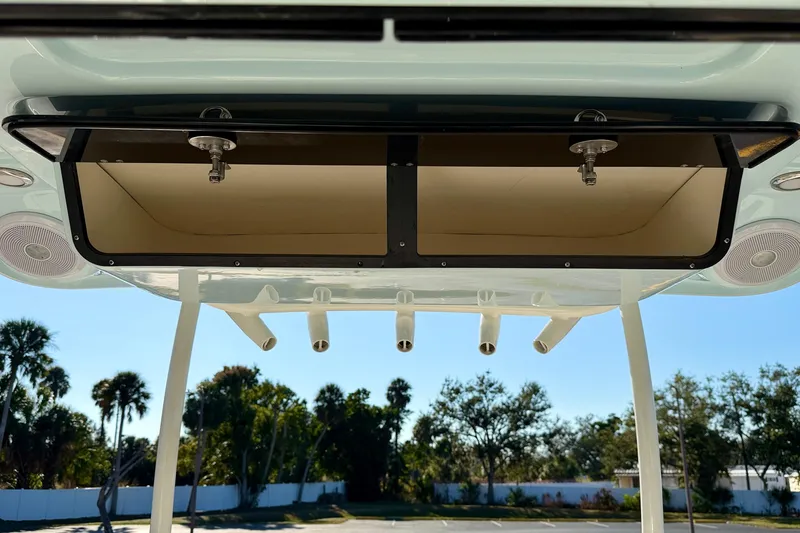 Slide: The Image of 2023 Key West 263 FS boat storage compartment with rod holders, outdoor setting. - 44
