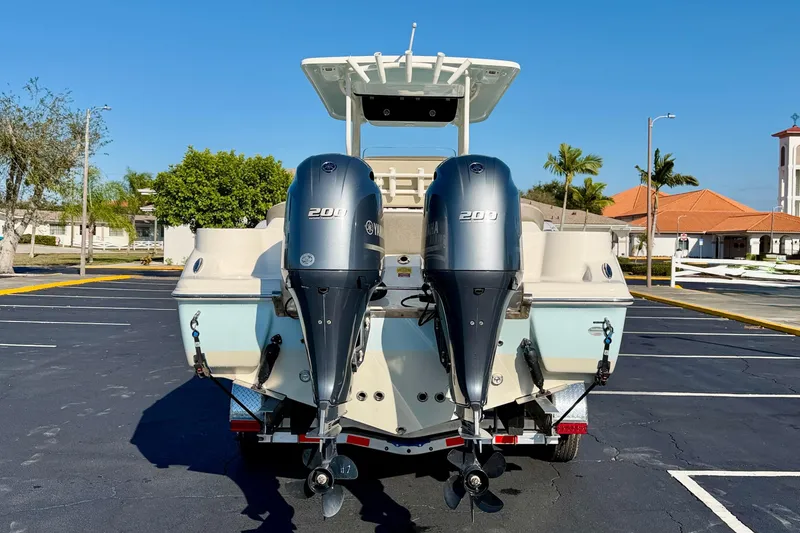 Slide: The Image of 2023 Key West 263 FS boat with dual Yamaha 200 engines in a parking lot. - 6