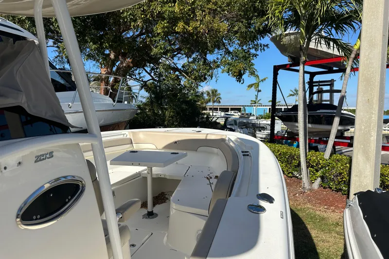 Slide: The Image of 2017 NauticStar 28 XS boat docked near palm trees and other boats. - 10