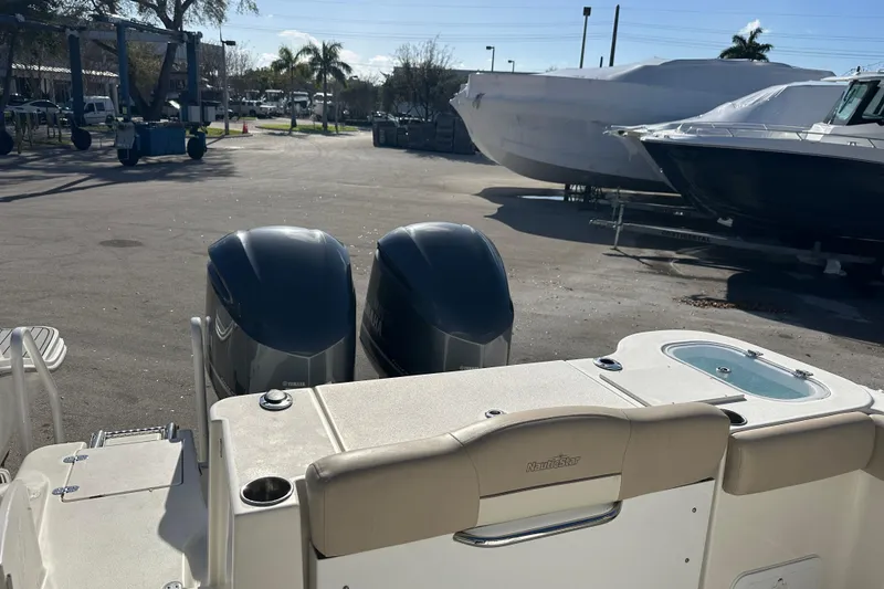 Slide: The Image of 2017 NauticStar 28 XS boat with dual outboard engines in a marina setting. - 11