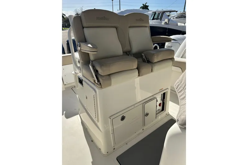 Slide: The Image of 2017 NauticStar 28 XS boat seating with storage compartments and controls. - 13