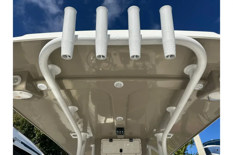Slide: The Image of 2017 NauticStar 28 XS boat roof with rod holders against blue sky. - 15
