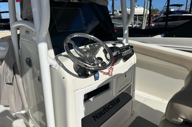 Slide: The Image of 2017 NauticStar 28 XS boat cockpit with steering wheel and control panel. - 7