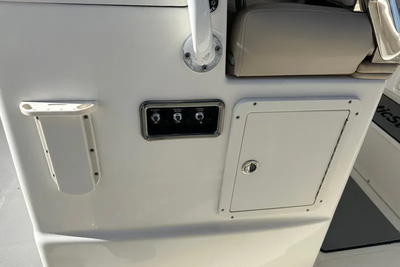 Slide: The Image of 2017 NauticStar 28 XS boat console with switches and storage compartment. - 9