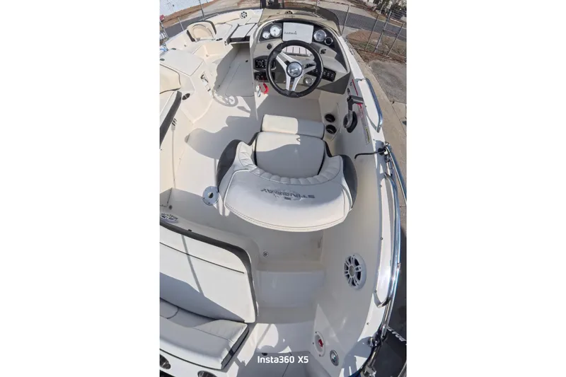 Slide: The Image of 2020 Stingray 212 SC boat interior with white seating and steering console. - 14
