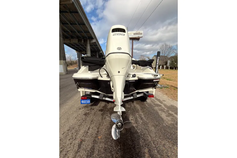 Slide: The Image of 2020 Stingray 212 SC boat on EZ Loader trailer, parked outdoors under a blue sky. - 3