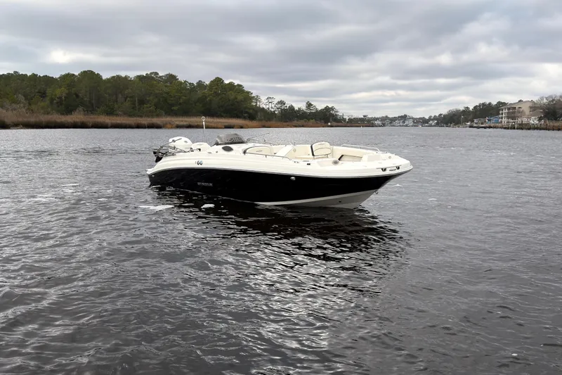 Slide: The Image of 2020 Stingray 212 SC boat with outboard motor on a trailer under a bridge. - 5