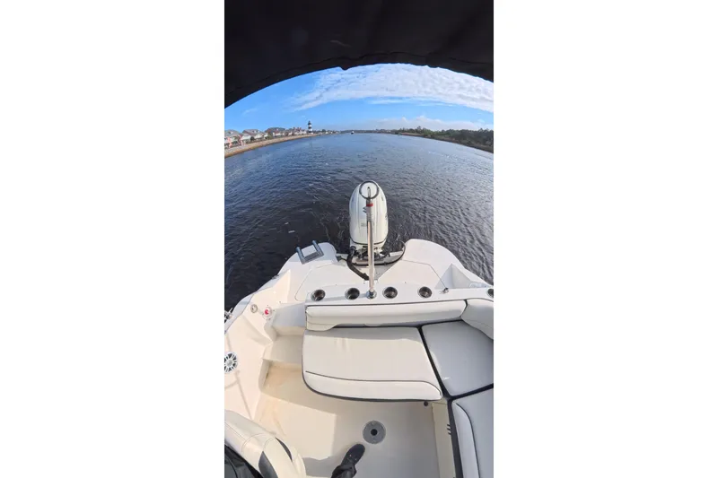 Slide: The Image of 2020 Stingray 212 SC boat on a calm river with scenic shoreline view. - 8