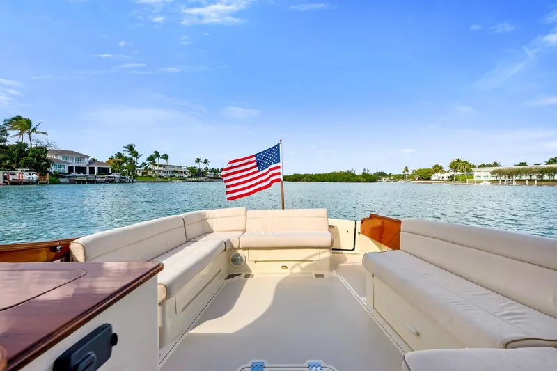 Slide: The Image of Luxurious 2015 Hinckley Talaria 43 Motoryacht with spacious seating and American flag on calm waters. - 15