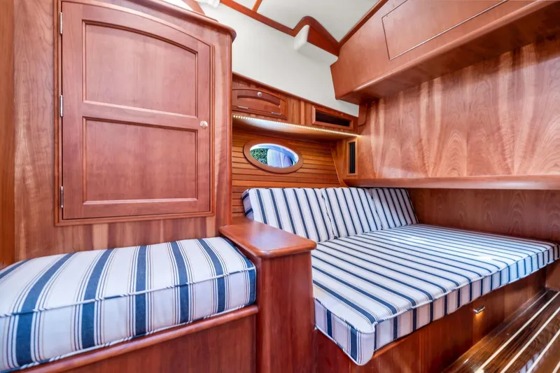 Slide: The Image of Interior of 2015 Hinckley Talaria 43 Motoryacht with striped seating and wooden cabinetry. - 10