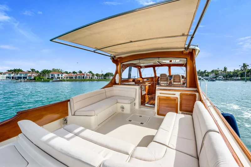 Slide: The Image of 2015 Hinckley Talaria 43 Motoryacht with spacious deck, luxurious seating, and scenic waterfront view. - 13