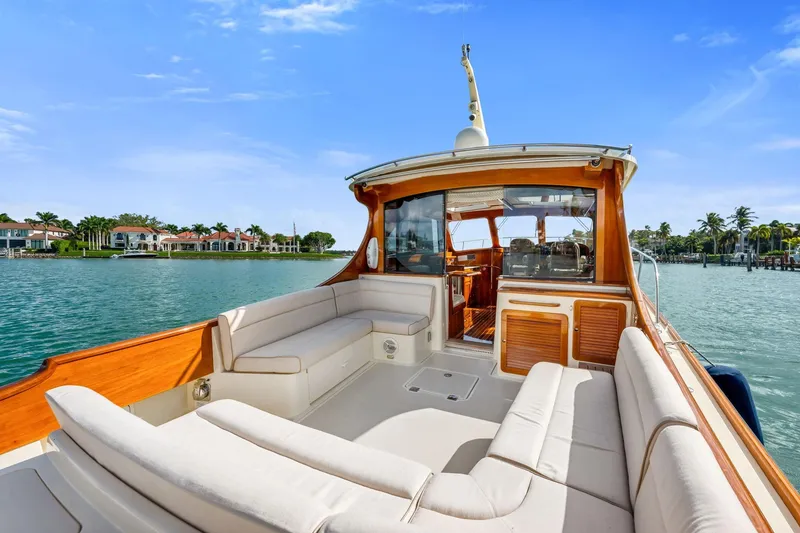 Slide: The Image of 2015 Hinckley Talaria 43 Motoryacht with spacious deck, luxurious seating, and scenic waterfront view. - 2
