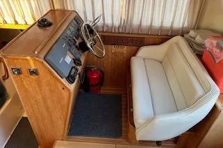 Slide: The Image of Interior helm of 2004 PDQ 34 Power Catamaran with white seating and wooden dashboard. - 13