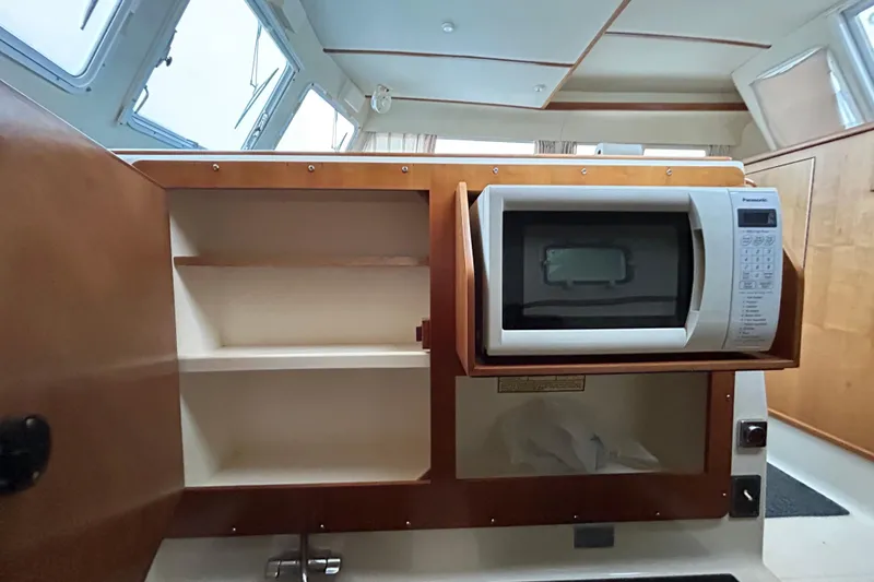 Slide: The Image of Interior of 2004 PDQ 34 Power Catamaran with microwave and open cabinet. - 18