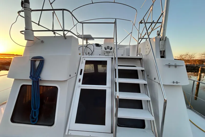 Slide: The Image of 2004 PDQ 34 Power Catamaran with stairs and railing at sunset. - 2