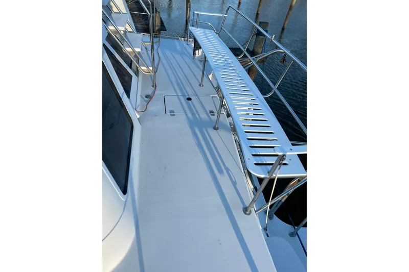 Slide: The Image of 2004 PDQ 34 Power Catamaran deck with metal railings and water view. - 22