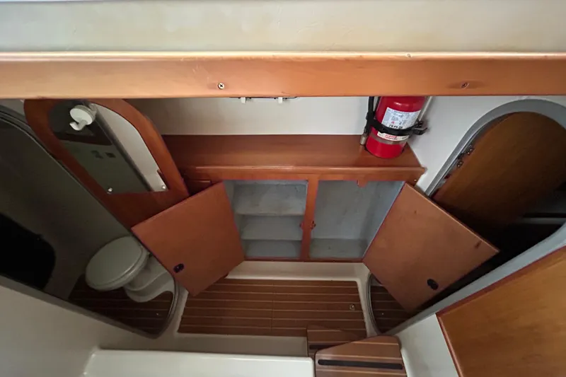 Slide: The Image of 2004 PDQ 34 Power Catamaran interior with wooden cabinets, fire extinguisher, and toilet. - 27