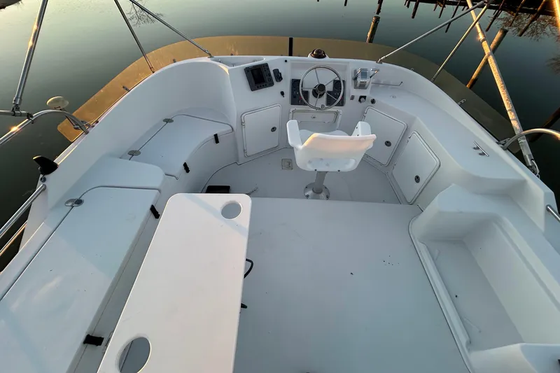 Slide: The Image of 2004 PDQ 34 Power Catamaran cockpit with steering wheel and seating area. - 5