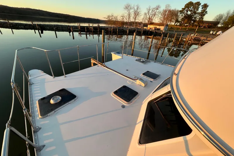 Slide: The Image of 2004 PDQ 34 Power Catamaran docked at serene waterfront during sunset. - 6